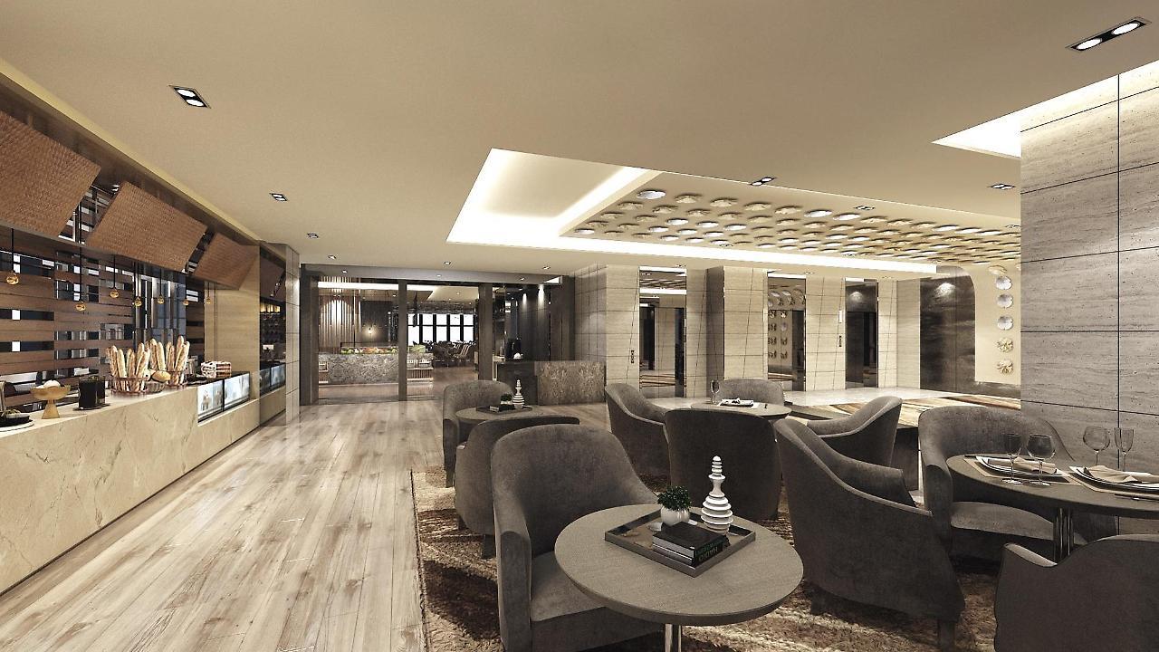 Caesar Metro Taipei Hotel Luaran gambar The image shows a modern and stylish interior space, likely a lounge or lobby area. The design features comfortable gray armchairs arranged around circular coffee tables. The flooring is made of light wood, contributing to a warm and inviting atmosph