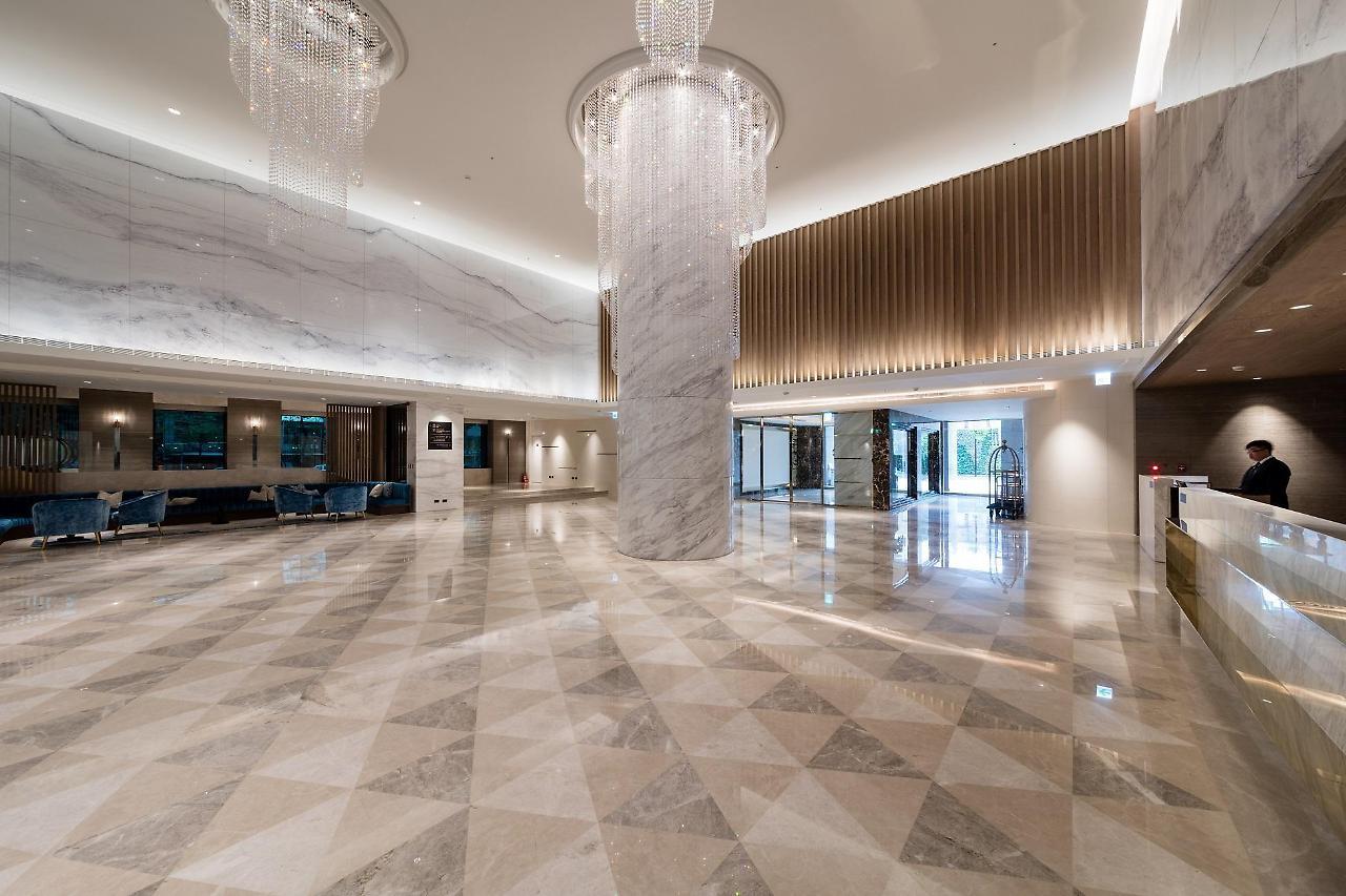 Caesar Metro Taipei Hotel Luaran gambar The photo shows a spacious and elegant hotel lobby. The floor is covered with large, polished tiles arranged in a diamond pattern, creating a sophisticated look. There are tall marble columns and stylish chandeliers hanging from the ceiling, adding t