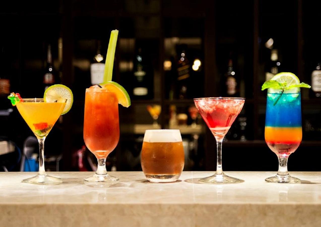 Caesar Metro Taipei Hotel Luaran gambar The photo displays a lineup of five different cocktails arranged on a bar counter. 

1. The first drink on the left is a colorful cocktail, likely garnished with a cherry and a slice of lime.
2. The second drink is a tall glass with an orange hue, fe